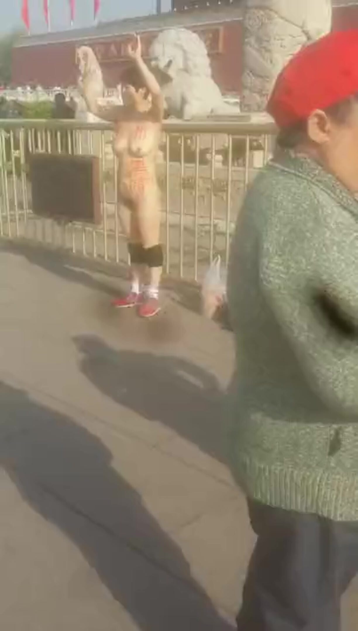 這麼冷的天，天安門廣場女主脫光衣服舉起雙手成投降狀，前身寫著似乎是廣州黑暗，不知道要幹嘛！